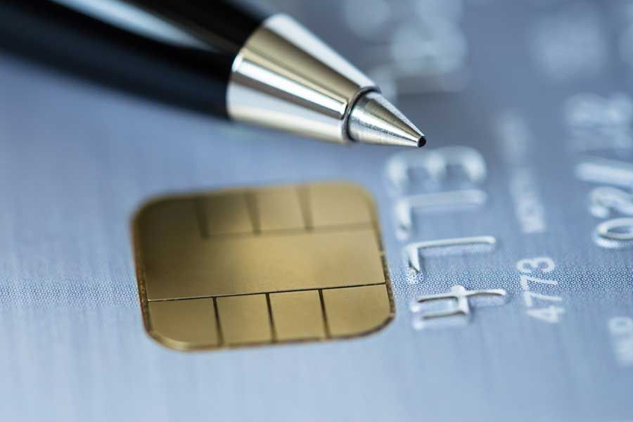 Close up of credit card chip and pen, secure electronic payment technology and financial transaction concept
