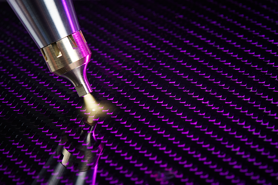 Atmospheric plasma nozzle treating carbon fibre composite surface under purple light for improved bonding in aerospace manufacturing