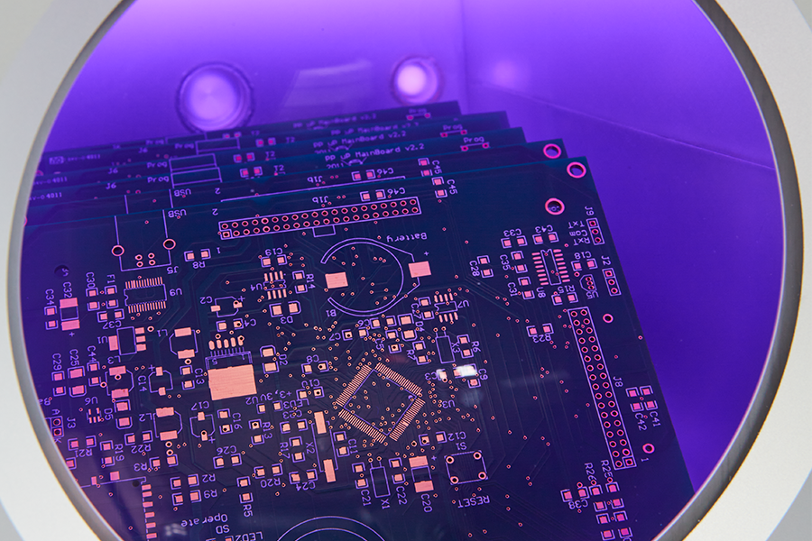 Printed circuit boards inside vacuum plasma chamber for PCB cleaning surface activation and improved conformal coating adhesion