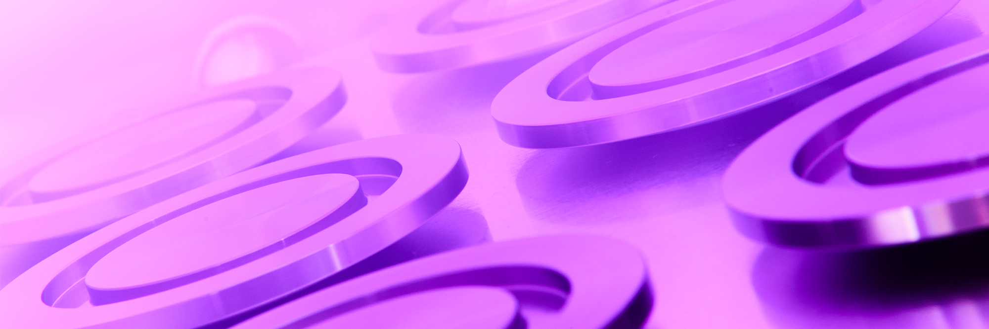Plasma treated precision metal components under purple glow for enhanced surface energy and improved adhesion bonding performance
